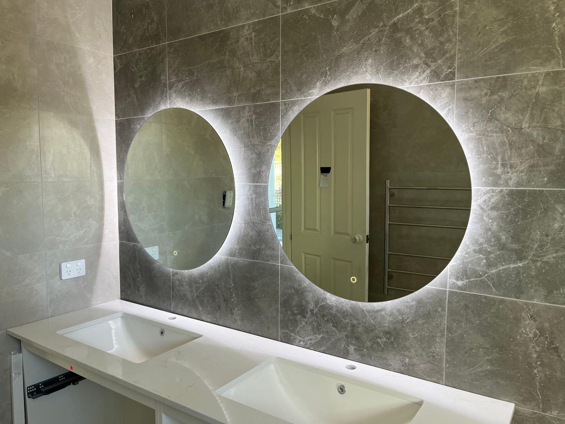 Renovated bathroom with backlit LED mirrors installed by Quantum