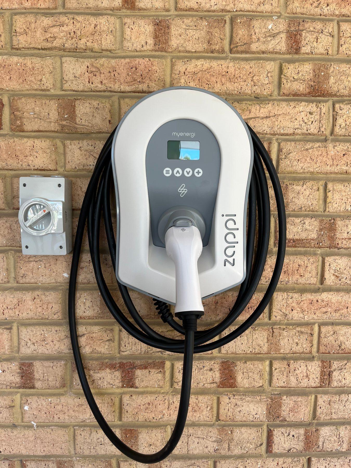Wall-mounted home EV charger installed on a brick wall