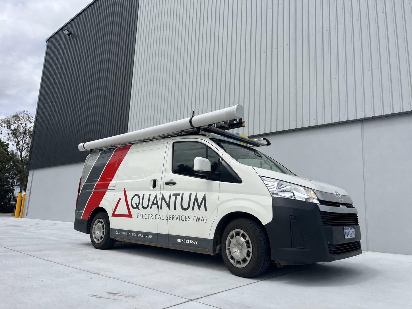 Branded Quantum Electrical Services van parked outside a commercial building