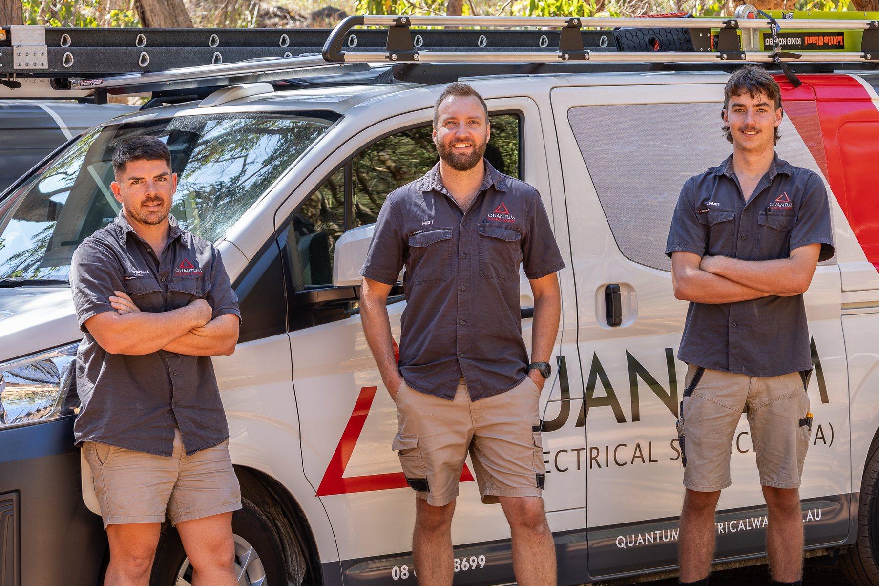 Quantum electricians standing in front of a branded Quantum van